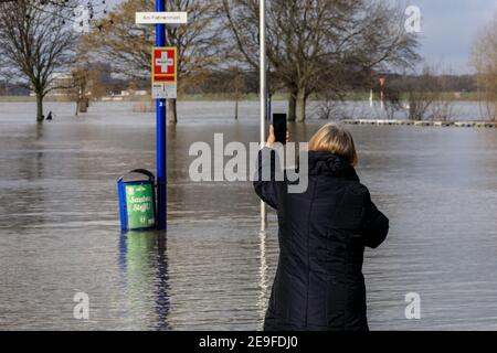 Duisburg, NRW, Allemagne. 04e fév. 2021. Une femme prend des photos des inondations. Les niveaux d'eau sur le Rhin ont augmenté à 9.25 mètres à Ruhrort près du port de Duisburg. La situation des inondations en Rhénanie-du-Nord-Westphalie est restée tendue jeudi avec des niveaux d'eau qui devraient augmenter le long du Rhin à Duisburg, ainsi que Düsseldorf, Wesel et Cologne, où les navires ne peuvent plus opérer. Credit: Imagetraceur/Alamy Live News Banque D'Images