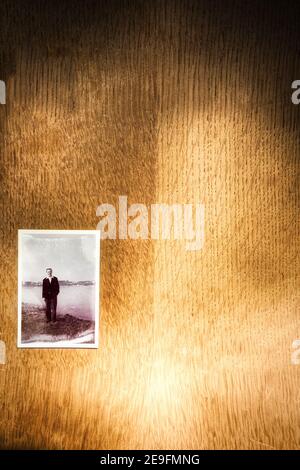 Juste au-dessus de la photographie des années 1950 de jeune homme souriant debout à côté de la mer sur fond de bois. Concept d'antan, nostalgie, années 1950 Banque D'Images