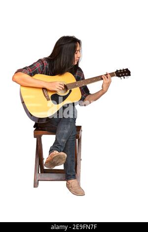 Portrait beau jeune homme guitariste avec de longs cheveux assis et jouant de la guitare acoustique. Homme asiatique à poil long jouant de la guitare acoustique isolé sur W Banque D'Images