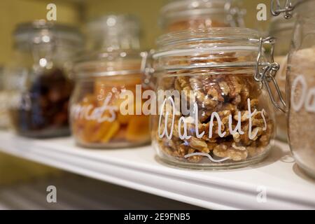 Photographie de fruits secs, de noix et de graines en pots de verre. Banque D'Images