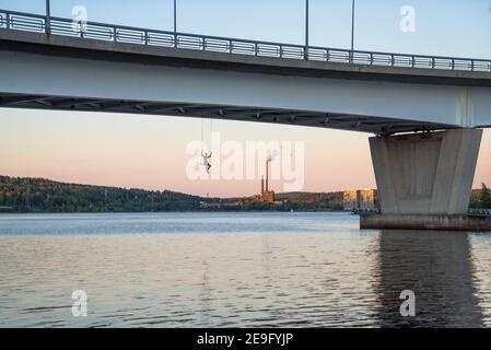 Pont Kuokkalan silta à Jyväskylä, en Finlande, au lac Jyväsjärvi. Dangereux, l'adrénaline balancer avec une personne sous le pont sur un beau coucher de soleil de soirée Banque D'Images