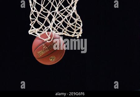 Filet de basket-ball gros plan avec ballon et fond noir. Banque D'Images