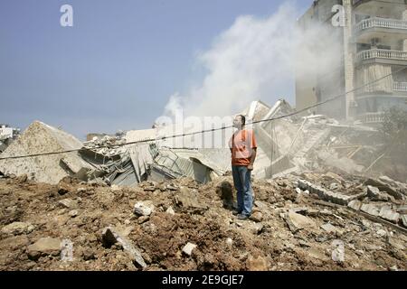 Un homme marche à travers les restes fumantes d'un bâtiment dans le quartier chiite de Choueifat, à la limite sud de Beyrouth, après qu'une bombe israélienne ait aplati le bâtiment tôt dans la matinée le 18 juillet 2006. Israël a également frappé une base militaire libanaise à l'extérieur de Beyrouth et a aplati une maison près de la frontière, tuant au moins 31 personnes dans une nouvelle vague d'attentats, tandis que le Hezbollah a lancé des roquettes sur le nord d'Israël. La communauté internationale a intensifié ses efforts diplomatiques pour mettre fin au conflit, qui a envoyé des étrangers fuyant par terre, par mer et par air. Photo de Michael Dorhn/ABACAPRESS.COM Banque D'Images