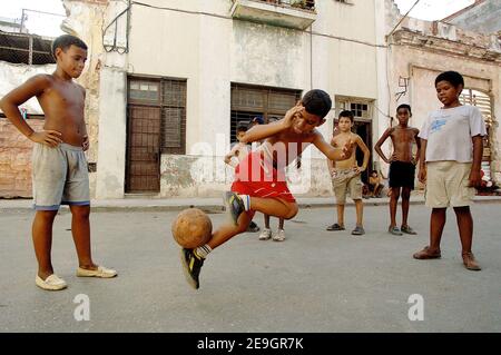 Les enfants jouant au football dans une rue à la Havane, Cuba, le 6 août 2006, six jours après qu'un Fidel Castro malade ait remis à son frère Raul un contrôle provisoire sur le gouvernement qu'il dirige sans interruption depuis 47 ans. Les citoyens cubains attendent de savoir si le "Lider Maximo" reprendra la direction après sa guérison d'une chirurgie intestinale. Photo par ABACAPRESS.COM Banque D'Images