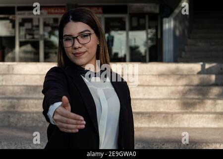 Peu profonde attention d'une jeune femme professionnelle hispanique qui tient sa main pour une poignée de main Banque D'Images