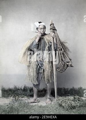 Photographie de la fin du XIXe siècle - ferme ouvrier fumant, Japon, vers 1880's, cool dans l'herbe manteau. Banque D'Images