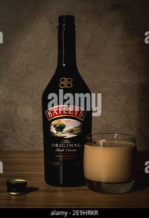 Bouteille ouverte de liqueurs Baileys avec verre rempli dans le bar Banque D'Images