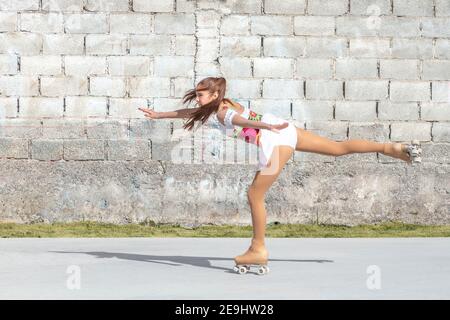 Une adolescente patineuse sur une jambe avec patins à roulettes. Patinage artistique Banque D'Images