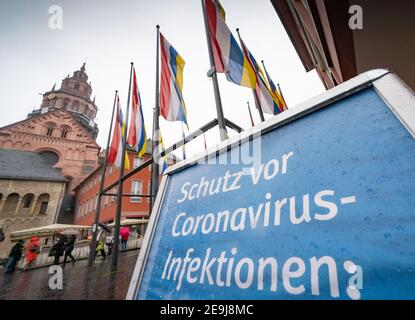 Mayence, Allemagne. 02 février 2021. Parmi les drapeaux des couleurs du carnaval de Mayence devant la cathédrale se trouve un panneau indiquant « protection contre les infections de Corona ». La procession traditionnelle du carnaval et l'agitation qui l'accompagne devront être annulées cette année. Credit: Frank Rumpenhorst/dpa/Alay Live News Banque D'Images