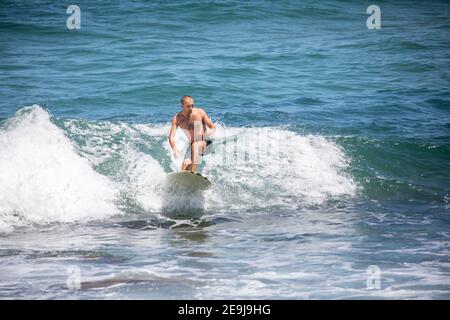 Homme adolescent surfant sur les vagues à Avalon Beach à Sydney Un jour d'été, Sydney, Australie Banque D'Images