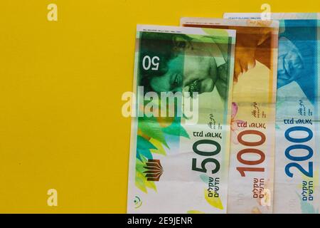 Nouveaux billets israéliens de cent deux cent cinquante shekels, fond jaune Banque D'Images