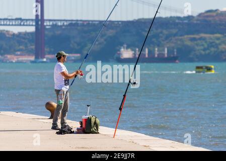 Portugal, Lisbonne, le 08 octobre 2018 : un homme avec une canne à pêche est en pêche sur un remblai. Banque D'Images