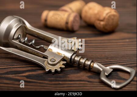 Tire-bouchon et bouchons de bouteilles de vin sur une table en bois. Gros plan, mise au point sélective. Banque D'Images