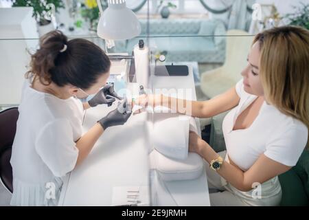 Une manucure féminine travaillant avec le client dans une beauté salon Banque D'Images