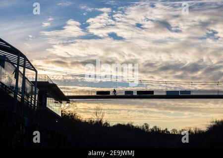 Silhouette de cycliste sur le nouveau pont au-dessus de Soca. Le pont n'est toujours pas terminé et n'est pas ouvert. Magnifique ciel de coucher de soleil derrière lui comme arrière-plan Banque D'Images