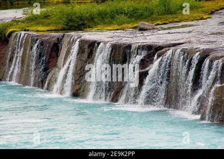 Hraunfossar plus que des cascades miniatures formées par des rivulets qui coulent sur une distance d'environ 900 mètres hors du Hallmundarhraun. Les cascades Banque D'Images