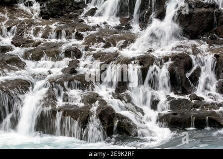 Hraunfossar plus que des cascades miniatures formées par des rivulets qui coulent sur une distance d'environ 900 mètres hors du Hallmundarhraun. Les cascades Banque D'Images