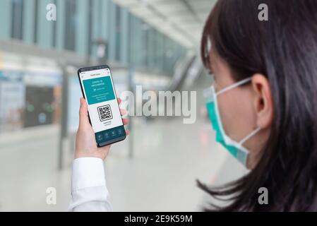 Concept de l'application Covid-19 Health Pass sur smartphone. Une femme hodling téléphone sur les départs de l'aéroport Banque D'Images