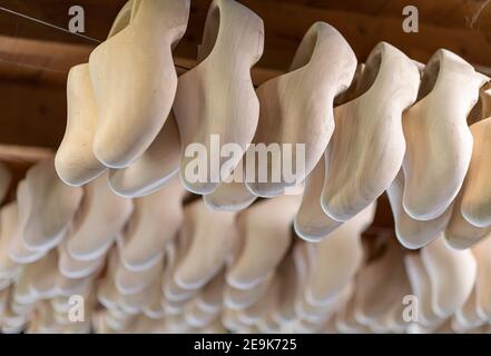 Collection de chaussures hollandaises en bois sur le plafond dans un Usine de sabots dans le nord des pays-Bas Banque D'Images