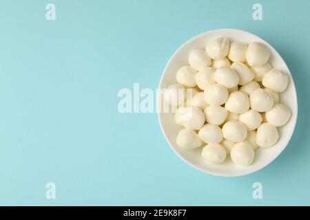 Bol avec fromage mozzarella frais sur fond bleu Banque D'Images