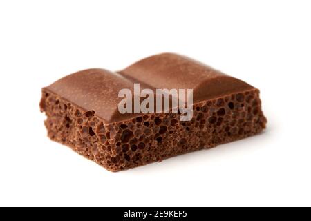 Gros plan d'un morceau de chocolat au lait aéré isolé sur arrière-plan blanc Banque D'Images