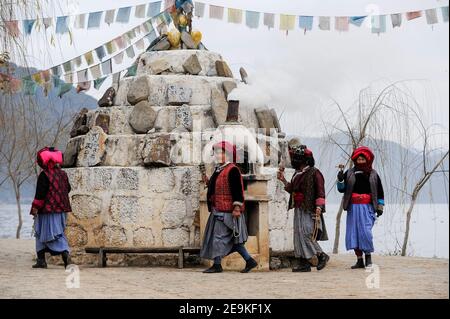 CHINE, province Yunnan, Xialuoshui, minorité ethnique Mosuo qui sont bouddhistes et les femmes exercent une matriargie, les vieilles femmes Mosuo avec des moulins de prière vont autour d'un sanctuaire bouddhiste à Lugu Lac / CHINE, Provinz Yunnan, ethnische Minderheit Mosuo , die Mosuo sind Buddhisten und Mosuo Frauen uein Matriarchaus, Frauen mit Gebetsmuehlen umrunden einen Schrein am Lugu Voir Banque D'Images