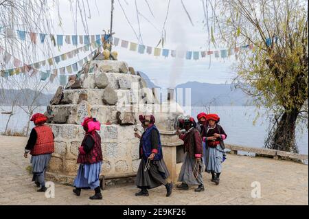 CHINE, province Yunnan, Xialuoshui, minorité ethnique Mosuo qui sont bouddhistes et les femmes exercent une matriargie, les vieilles femmes Mosuo avec des moulins de prière vont autour d'un sanctuaire bouddhiste à Lugu Lac / CHINE, Provinz Yunnan, ethnische Minderheit Mosuo , die Mosuo sind Buddhisten und Mosuo Frauen uein Matriarchaus, Frauen mit Gebetsmuehlen umrunden einen Schrein am Lugu Voir Banque D'Images