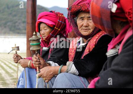 CHINE, province Yunnan, Lac Lugu, Xialuoshui, minorité ethnique Mosuo qui sont bouddhistes et les femmes exercent une matriargie, vieilles femmes Mosuo avec des moulins de prière / CHINE, Yunz Provinnan, Lac Lugu, ethnische Minderheit Mosuo , die Mosuo sind Buddhisten und Mosuo Frauen ueben Matrihuein Metrihbetuen mit Geomen mit Banque D'Images