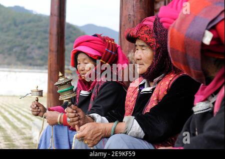 CHINE, province Yunnan, Lac Lugu, Xialuoshui, minorité ethnique Mosuo qui sont bouddhistes et les femmes exercent une matriargie, vieilles femmes Mosuo avec des moulins de prière / CHINE, Yunz Provinnan, Lac Lugu, ethnische Minderheit Mosuo , die Mosuo sind Buddhisten und Mosuo Frauen ueben Matrihuein Metrihbetuen mit Geomen mit Banque D'Images