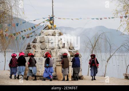 CHINE, province Yunnan, Xialuoshui, minorité ethnique Mosuo qui sont bouddhistes et les femmes exercent une matriargie, les vieilles femmes Mosuo avec des moulins de prière vont autour d'un sanctuaire bouddhiste à Lugu Lac / CHINE, Provinz Yunnan, ethnische Minderheit Mosuo , die Mosuo sind Buddhisten und Mosuo Frauen uein Matriarchaus, Frauen mit Gebetsmuehlen umrunden einen Schrein am Lugu Voir Banque D'Images