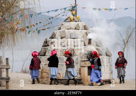 CHINE, province Yunnan, Xialuoshui, minorité ethnique Mosuo qui sont bouddhistes et les femmes exercent une matriargie, les vieilles femmes Mosuo avec des moulins de prière vont autour d'un sanctuaire bouddhiste à Lugu Lac / CHINE, Provinz Yunnan, ethnische Minderheit Mosuo , die Mosuo sind Buddhisten und Mosuo Frauen uein Matriarchaus, Frauen mit Gebetsmuehlen umrunden einen Schrein am Lugu Voir Banque D'Images