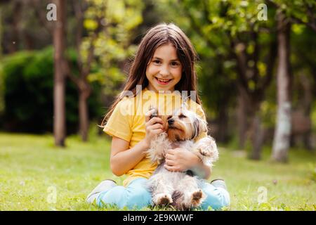 le petit enfant tient un petit chien Banque D'Images