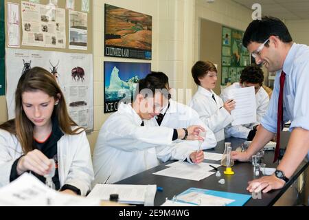 les adolescents d'un cours de sciences étant instruisant par un enseignant Banque D'Images