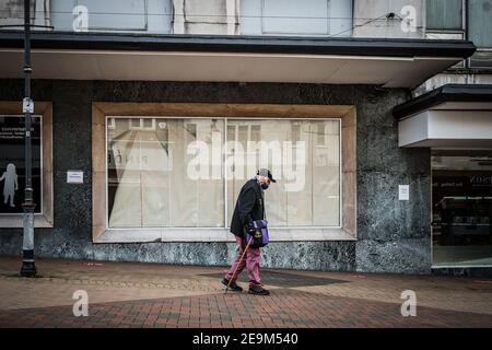 Une femme seule qui se promeuna devant un pub fermé est montée à bord maison comme la ville va dans la récession et les magasins à proximité Confinement pandémique Covid 19 Banque D'Images