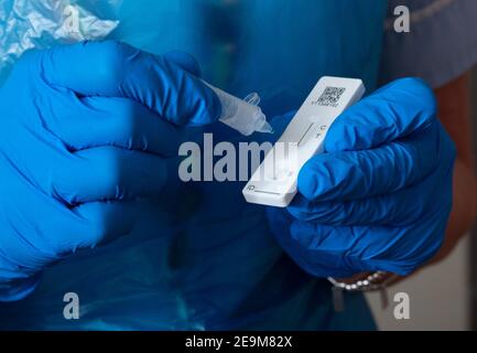 Test qualitatif rapide de l'antigène Innova SARS-CoV-2. Des gouttes de solution d'extraction sont déposées sur la barre de test dans un kit de test rapide. Banque D'Images