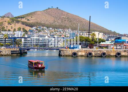 Front de mer- Cape Town, Afrique du Sud - 03-02-2021 vue imprenable sur le ferry Red Penny flottant sur l'eau, la montagne et le pont traversant. Banque D'Images