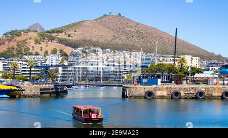 Front de mer- Cape Town, Afrique du Sud - 03-02-2021 vue imprenable sur le ferry Red Penny flottant sur l'eau, la montagne et le pont traversant. Banque D'Images