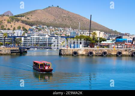 Front de mer- Cape Town, Afrique du Sud - 03-02-2021 vue imprenable sur le ferry Red Penny flottant sur l'eau, la montagne et le pont traversant. Banque D'Images