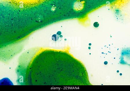 Les aquarel brillants liquides avec de l'huile génèrent des structures fluides et des bulles en vert, bleu, jaune, blanc et or Banque D'Images