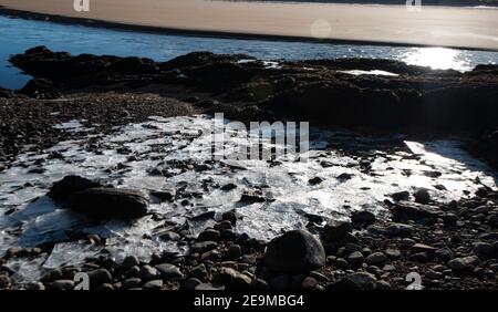 Eau douce gelée sur la plage/rochers. Feuille de glace Banque D'Images