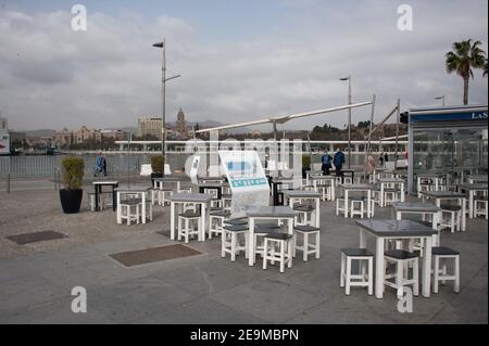 Malaga, Espagne. 05 février 2021. Un couple portant un masque facial a vu passer devant un restaurant 'sureña' vide et fermé dans une zone commerciale de Malaga.de nombreux magasins, magasins et activités non essentielles qui ont fermé en raison de la troisième vague de pandémie de coronavirus montrent encore des situations vides dans divers endroits de la ville de Malaga, au moins jusqu'au 15 février. Crédit : SOPA Images Limited/Alamy Live News Banque D'Images