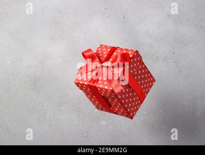 Boîte cadeau en papier rouge avec ruban rouge sur fond clair. Concept de la Saint-Valentin, anniversaire, Fête des mères Banque D'Images