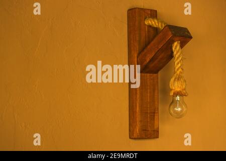 Focus sélectif de la décoration de maison de la lampe murale fixée sur le panneau de bois avec corde. Banque D'Images