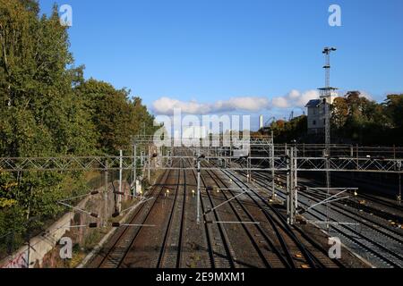 Chemin de fer à Helsinki, Finlande. Photographié sept. 2019. Plusieurs voies de train avec lignes d'alimentation électrique, quelques arbres, ciel bleu et le Mall of Tripla. Banque D'Images