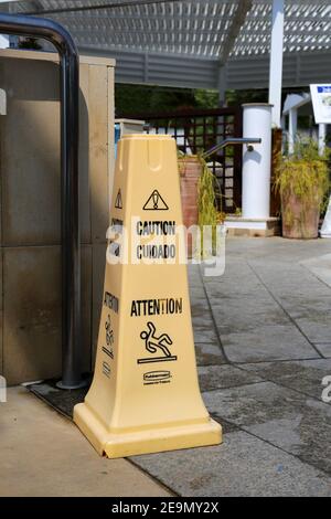 Signes de mise en garde sur les sols glissants et humides en plusieurs langues. Accroître la sécurité et la prudence au bord d'une piscine dans la station balnéaire. Plage et piscine en vacances Banque D'Images