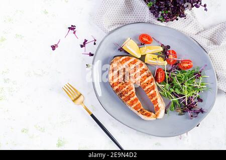 Saumon. Saumon, steak de poisson grillé et salade de tomates avec micro-légumes. Une alimentation saine. Vue de dessus, au-dessus de la tête, espace de copie. Banque D'Images