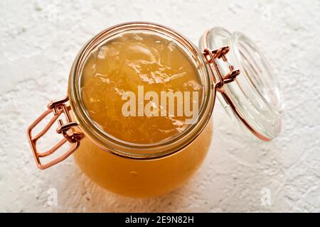 Refroidir le bouillon d'os de bœuf congé dans un pot en verre sur une table blanche Banque D'Images