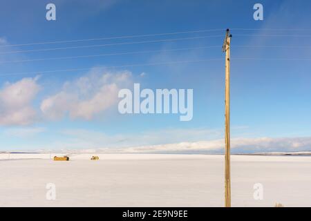 Poteau téléphonique et neige ont couvert de vastes terres agricoles d'espace ouvert à Hiver Banque D'Images