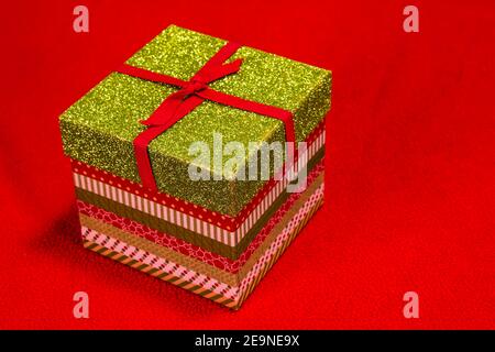 Boîte cadeau de Noël multicolore sur fond rouge Banque D'Images