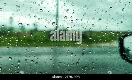 Gouttes d'eau sur la fenêtre de la voiture avec vue à la lunette arrière Banque D'Images